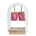 Pair of earrings with pink backs on a white stand