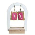 Pair of earrings with pink backs on a white stand