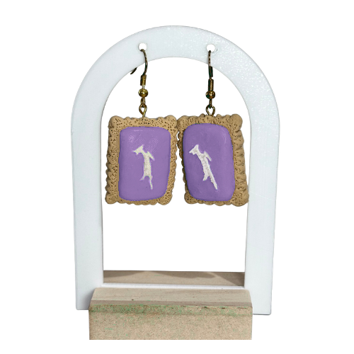 Pair of earrings with purple heart designs on a white stand.
